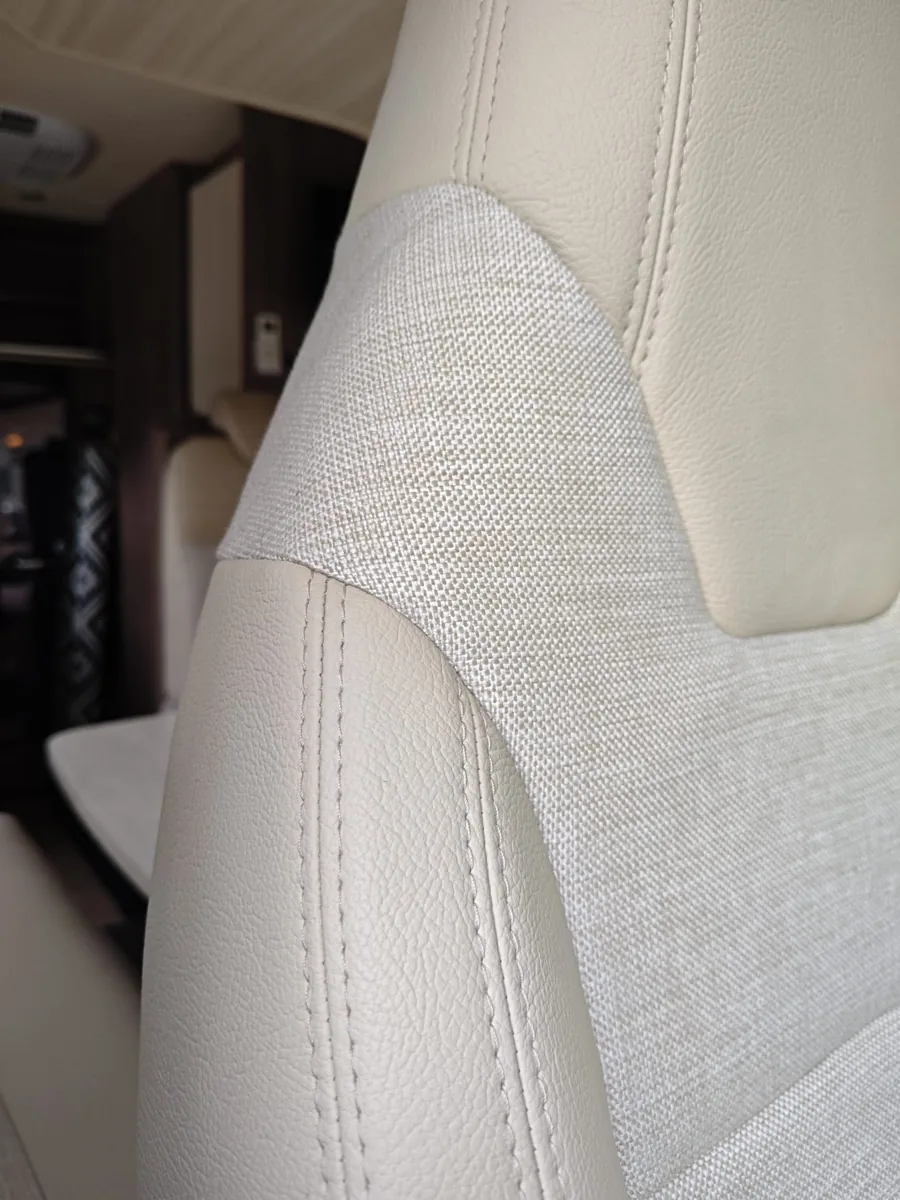 Detail van geweven stof en dubbele stiksels in lichte bekleding